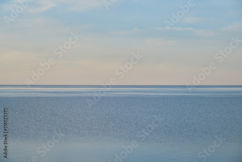 Blue pond and horizon line in distance. Clear summer sky. Beautiful seascape. Lake Ilmen, Novgorod region, Russia.