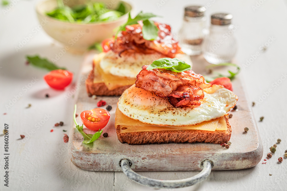 Homemade and tasty toasts with eggs, tomatoes and bacon.