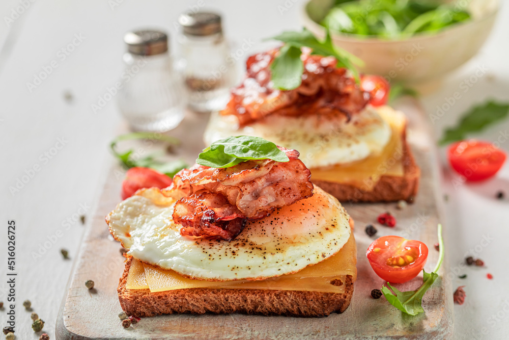 Tasty and fresh toasts with toast, bacon and eggs.