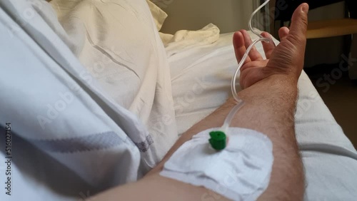Man attached to a drip in a hospital, first person view