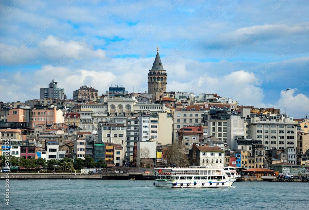 Galata tower hill with building with ferry boat on Golden Horn in Istanbul