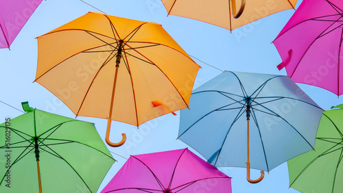 Beautiful multicolored umbrellas from a low angle. Summer holiday city scape concept.