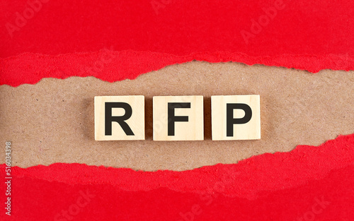 RFP word on wooden cubes on red torn paper , financial concept background