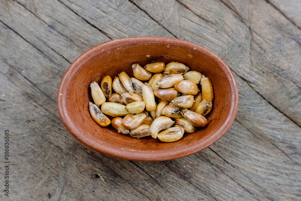 Toasted Andean corn with salt served on a rustic bowl, on a wooden table. Top view. Peruvian food Toasted Andean corn with salt served on a rustic bowl, on a wooden table. Top view. Peruvian food