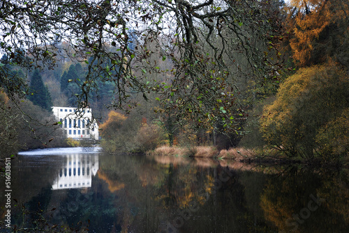 The perfect reflection of a hydroelectric power plant, on the unusually calm waters of the River Clyde, near New Lanark, Scotland photo