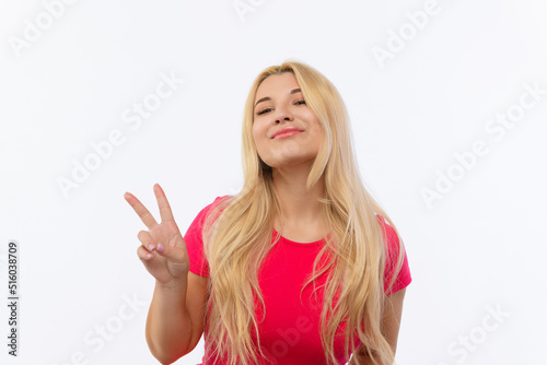 a girl in a pink dress on a white background shows a peace sign