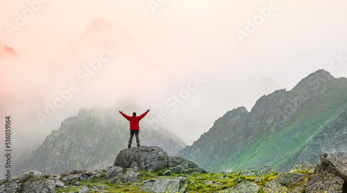 Hiker standing on the top of the mountain peak.