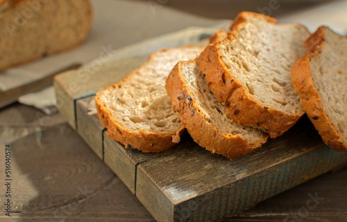 Close-up of sliced rye bread with cereals on a wooden board. Selective focus. Tinting. The concept of healthy eating.