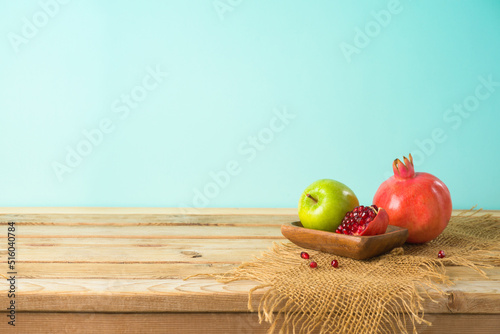 Jewish holiday Rosh Hashana background with honey, apple and pomegranate on wooden table