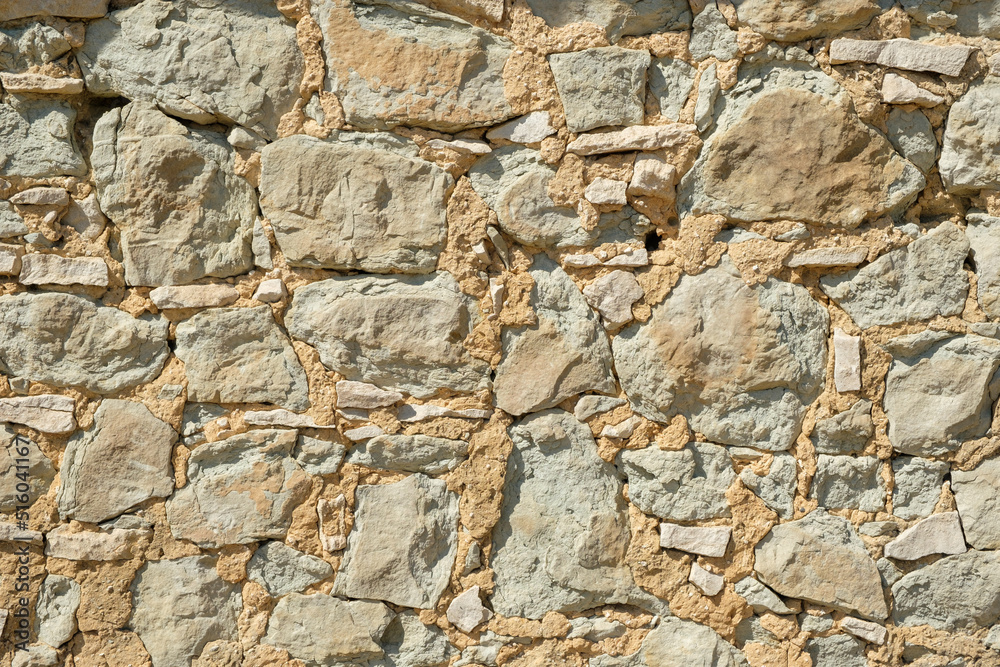 Ancient stonewall with irregular pattern and grungy atmosphere from house in Carpentras, France