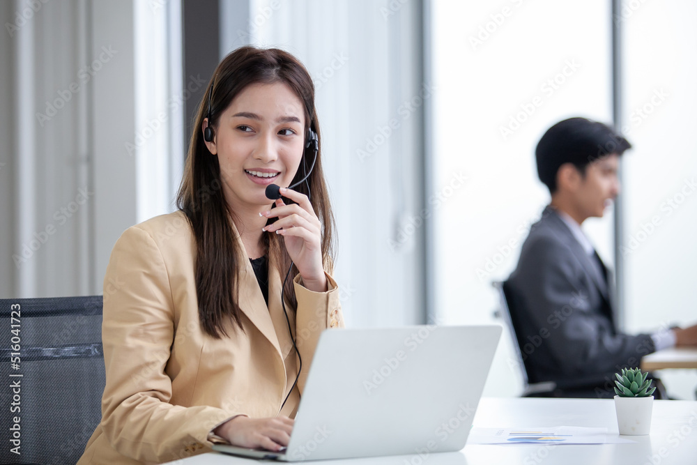 female operator agent with headsets and her team working in a call center customer service office. Asian employee woman working with a headset, Customer support. female operator agent with headsets and her team working in a call center customer service office. Asian employee woman working with a headset, Customer support.