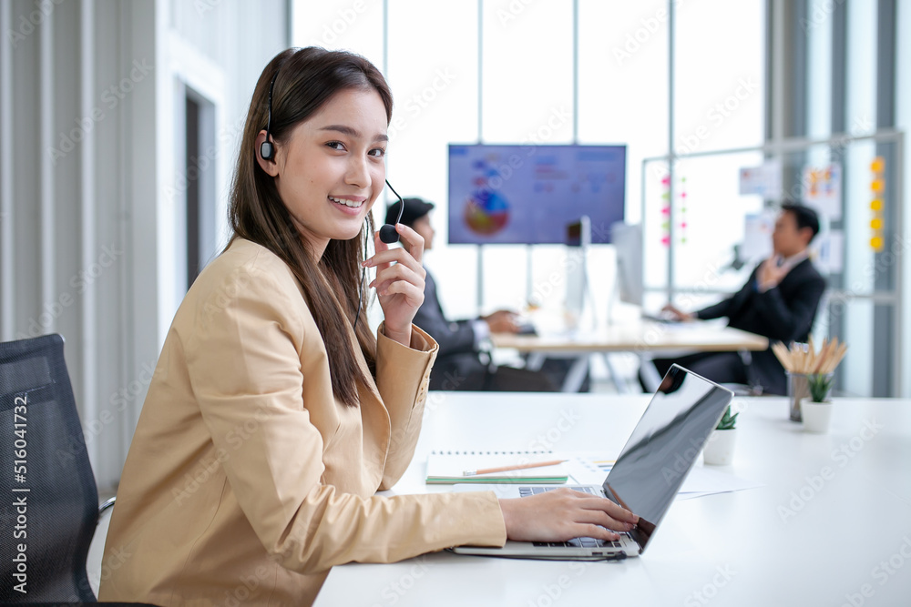 female operator agent with headsets and her team working in a call center customer service office. Asian employee woman working with a headset, Customer support. female operator agent with headsets and her team working in a call center customer service office. Asian employee woman working with a headset, Customer support.