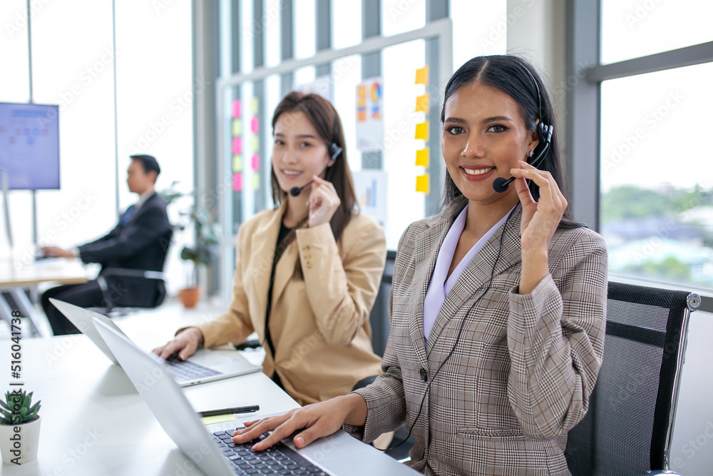 female operator agent with headsets and her team working in a call center customer service office. Asian employee woman working with a headset, Customer support. female operator agent with headsets and her team working in a call center customer service office. Asian employee woman working with a headset, Customer support.
