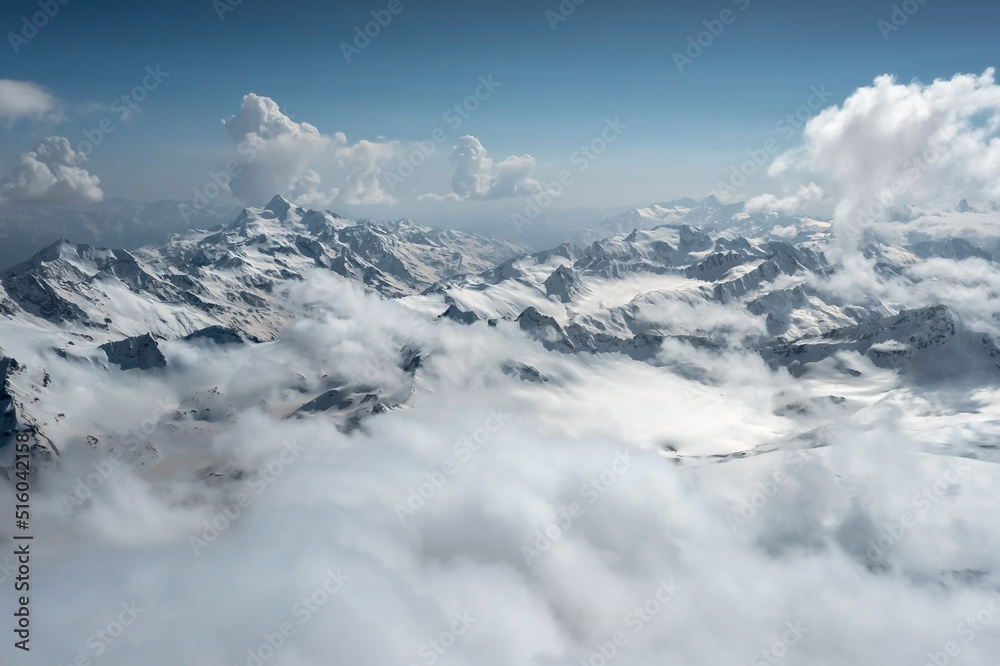 Aerial panoramic landscape with mountains partially hidden behind low clouds, Caucasus, Russia
