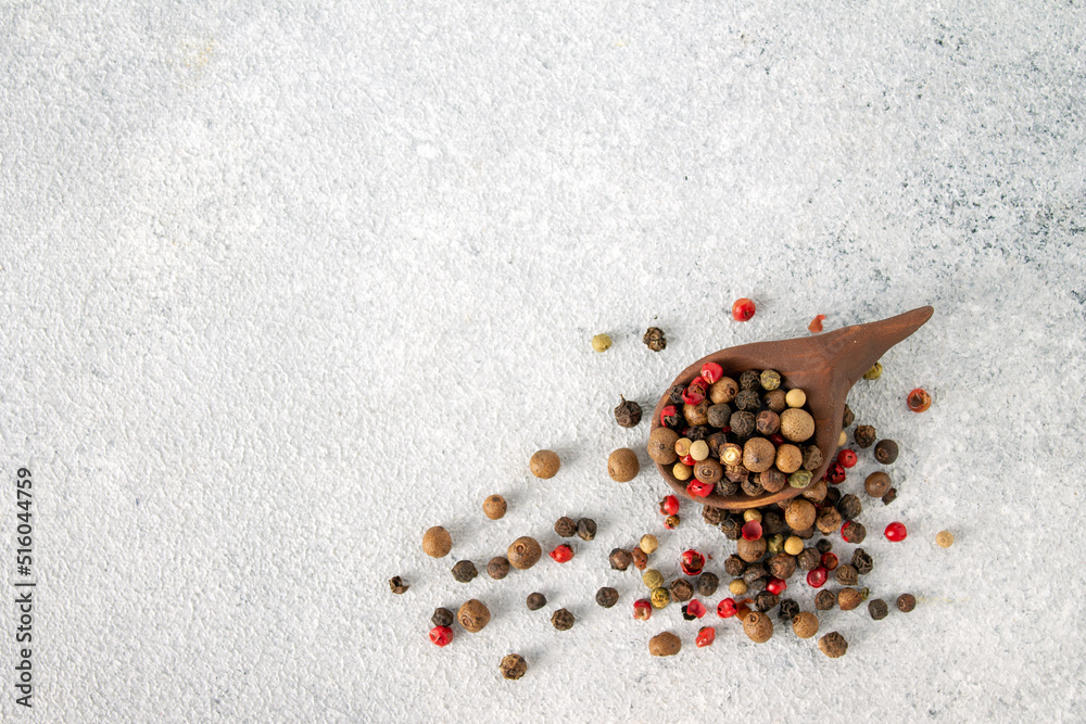 peppercorns crumbled from a wooden spoon, copy space peppercorns crumbled from a wooden spoon, copy space