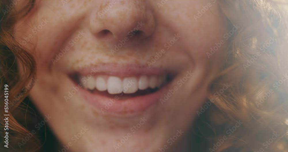 Close up smiling female mouth with white teeth. Woman with red curly hairs. Stand at sunlight. Slow motion Close up smiling female mouth with white teeth. Woman with red curly hairs. Stand at sunlight. Slow motion