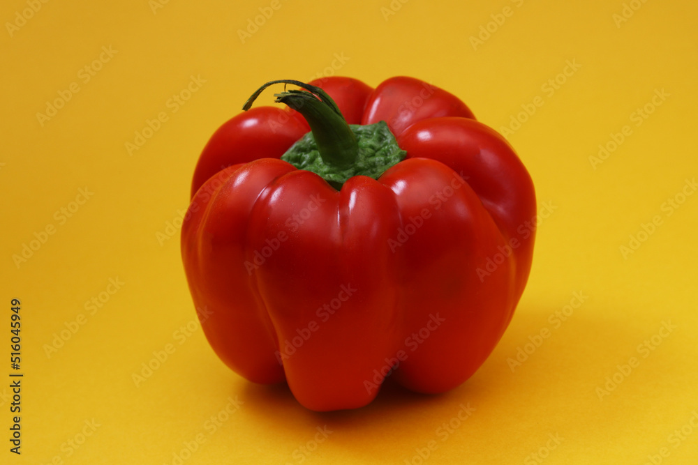 Big red pepper on an orange background. Close-up Big red pepper on an orange background. Close-up