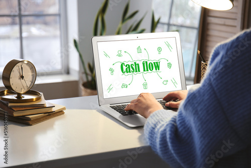 Woman working with modern laptop at home. Cash flow