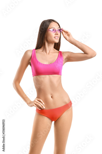 Young tanned woman in swimsuit and sunglasses on white background © Pixel-Shot