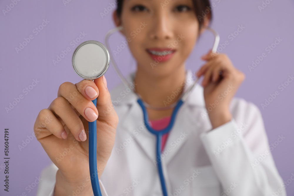 Asian doctor with stethoscope on lilac background, closeup Asian doctor with stethoscope on lilac background, closeup