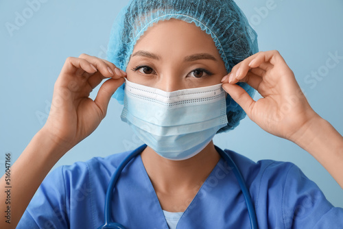 Asian nurse putting on medi...
