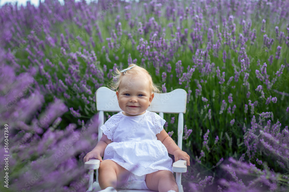 Smiling  baby girl sitting at lavender meadow.