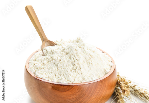 Bowl with flour, scoop and wheat ears on white background