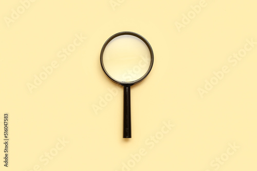 Magnifying glass on beige background