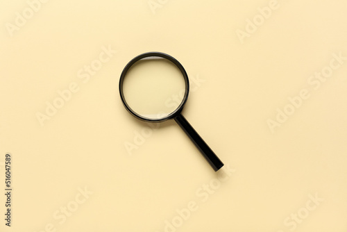 Magnifying glass on beige background