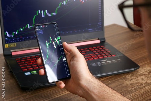 planning and strategy, Stock market, Hands of business people working with smart phone. Technical price graph and indicator, red and green candlestick chart and stock trading mobile screen background photo
