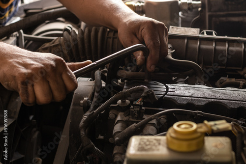 Mãos de um mecânico consertando carro