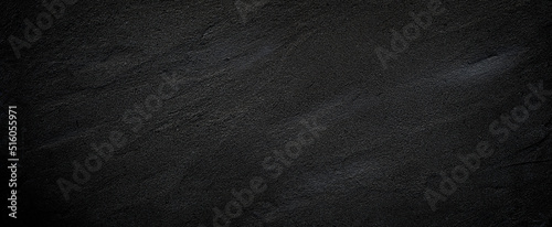 Black or dark gray rough grainy stone or sand texture background