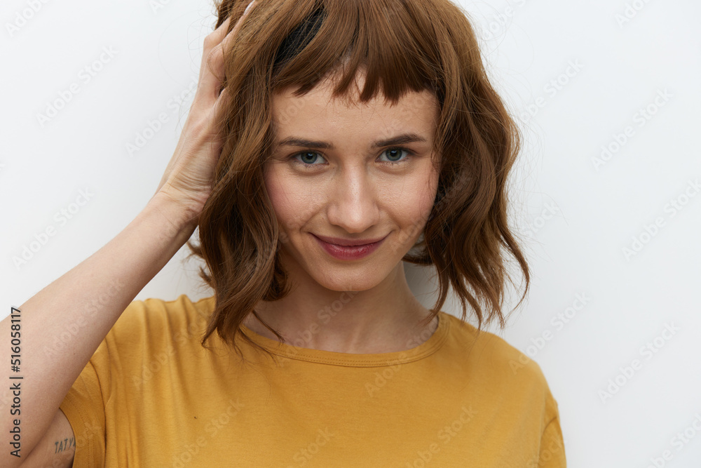 a sexy, attractive woman with short red hair stands holding them with her hand and looks into the camera smiling pleasantly a sexy, attractive woman with short red hair stands holding them with her hand and looks into the camera smiling pleasantly
