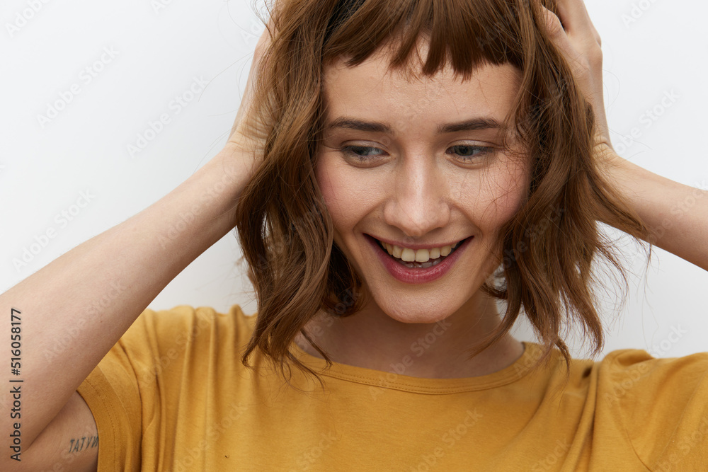 a sexy, attractive woman with short red hair stands holding them on both sides with her hands and looks down with a pleasant smile a sexy, attractive woman with short red hair stands holding them on both sides with her hands and looks down with a pleasant smile