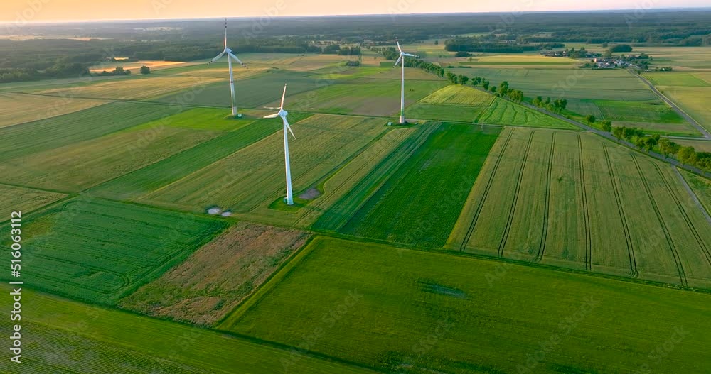 Aerial drone view of wind power turbines, part of a wind farm. Wind turbines on green field in countryside. Wind power plant. Aerial drone view of wind power turbines, part of a wind farm. Wind turbines on green field in countryside. Wind power plant.