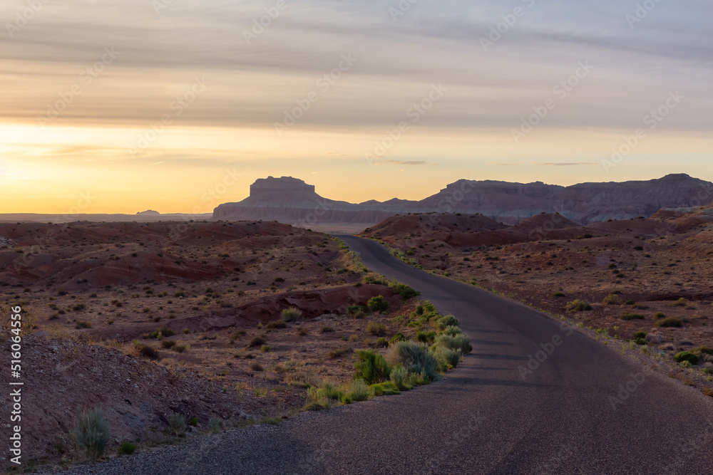 Scenic Road surrounded by Red Rock Mountains in the Desert at Sunrise. Spring Season. Goblin Valley State Park. Utah, United States. Nature Background.