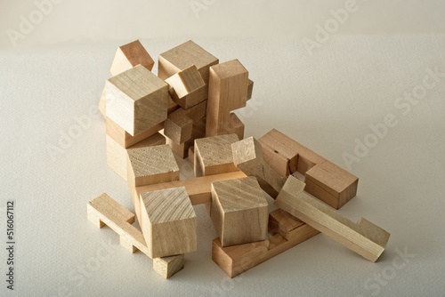 Pile of three dimensional wooden puzzle block pieces on textured paper surface