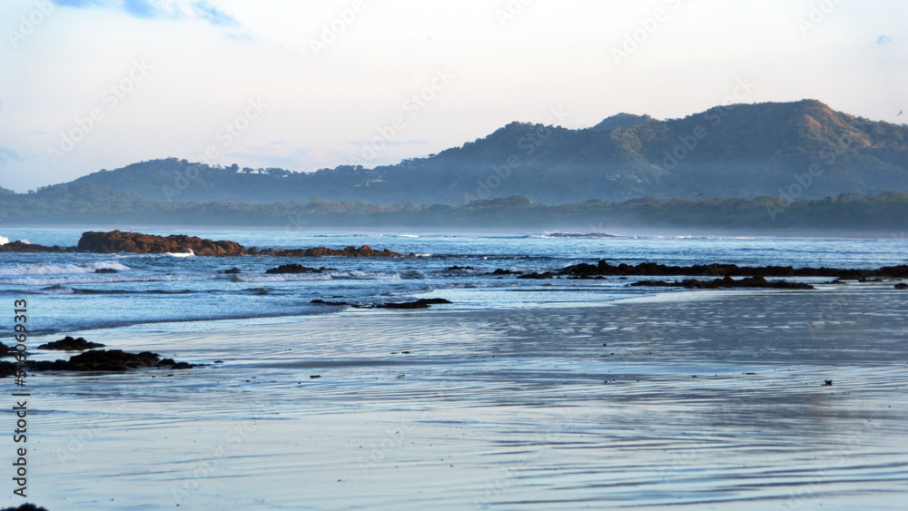Sunrise on the beach in Tamarindo, Costa Rica, with mountains in the distance