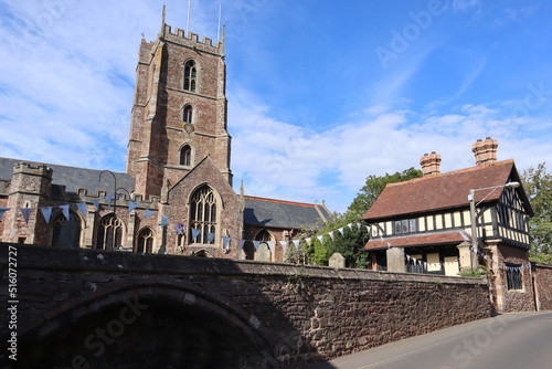 The priory church of Saint George and the Priest's House both in the churchyard in the village of Dunster in Somerset, England