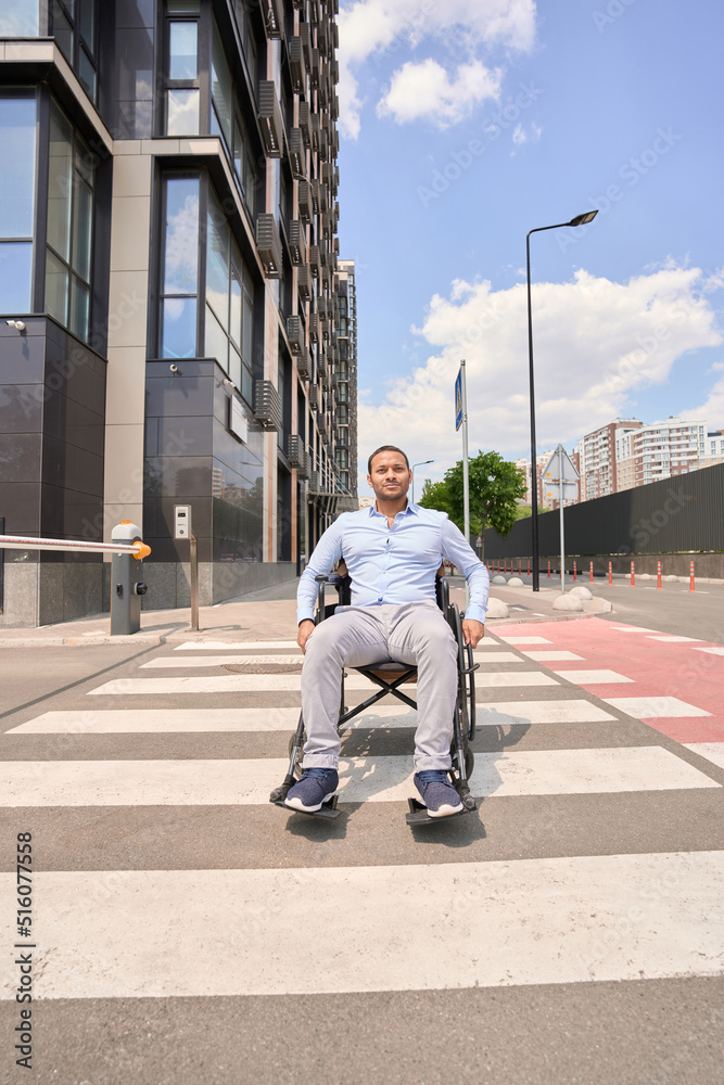 Disabled man in manual wheelchair on zebra crossing Disabled man in manual wheelchair on zebra crossing