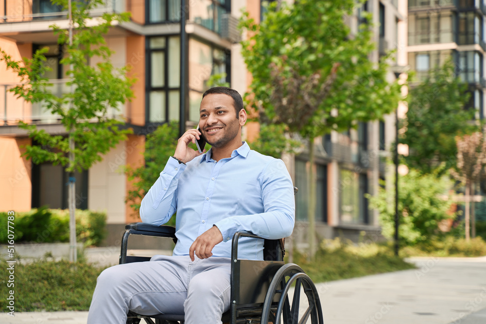 Cheerful disabled male person talking on cellphone Cheerful disabled male person talking on cellphone