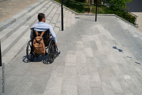 Photo Man with disability descending concrete staircase outdoors