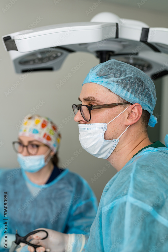Surgeon in uniform and mask working in hospital. Surgical confident male doctor.