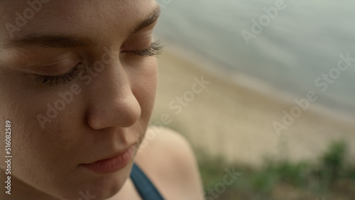 Closeup girl face meditating on beach. Portrait of focused woman doing yoga
