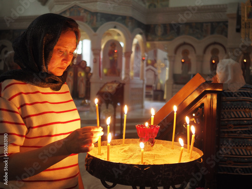 Tableau sur toile A woman in an Orthodox church puts candles.