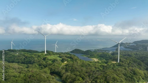 Aerial timelapse: Turbines spin as clouds move over coastal wind farm