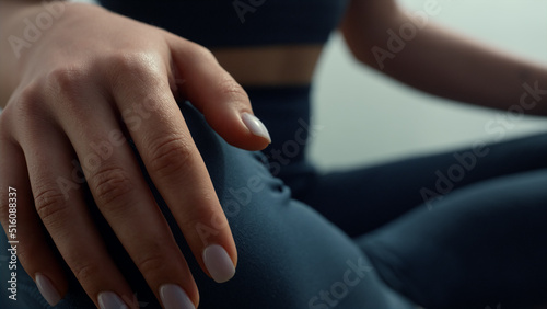 Fit woman keep hands on knees meditating on seashore. Girl practicing yoga.