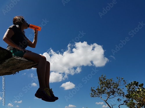 Woman sitting on the edge of a rock over an abyss