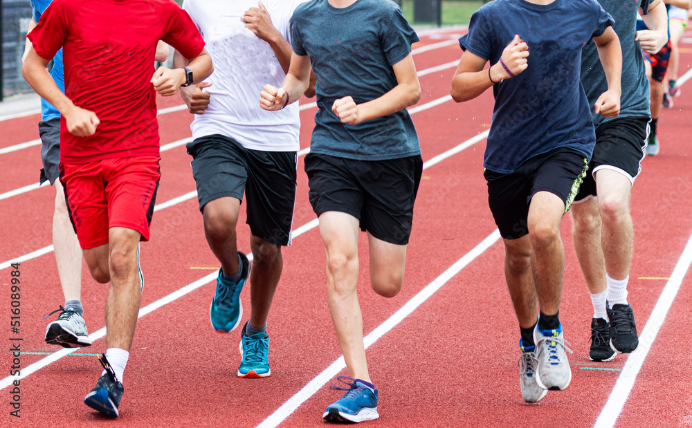 High school runners running together on a track High school runners running together on a track