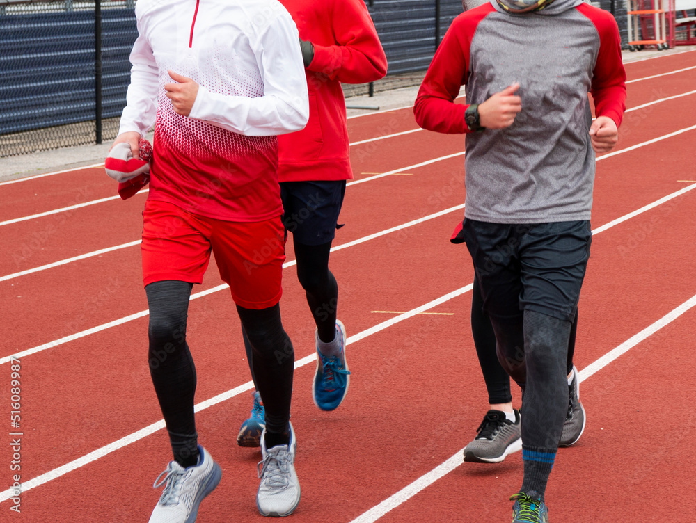 Fototapeta premium Small group of boys running together on a track